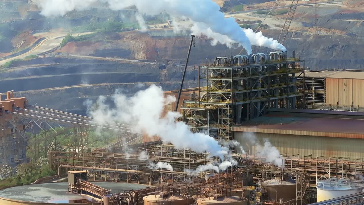 Barrick Gold mine in Cotui, steam rising from industrial smokestacks and processing units, Dominican Republic. Aerial drone