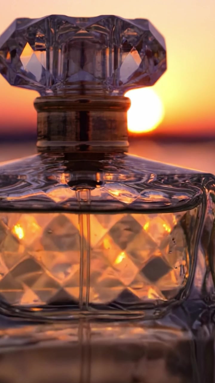Un'Affascinante Bottiglia di Profumo in Vetro Scintilla Contro un Tramonto Mozzafiato, Riflettendo Tonalità Calde ed Eleganza Che Catturano i Sensi.