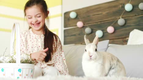chica sonriente alimentando al conejo