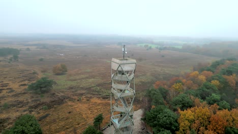 imágenes aéreas de una torre de vigilancia contra incendios, un hombre disfruta de la vista en un frío día de otoño