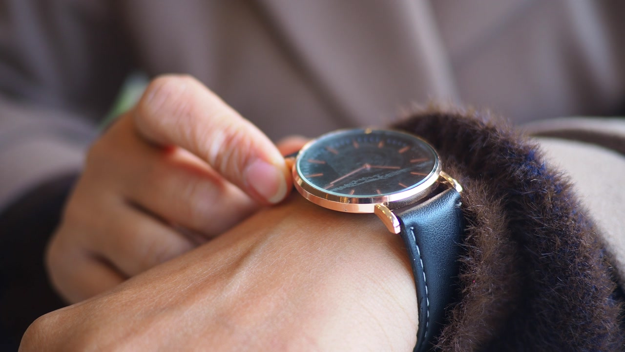 Close-up of a Person's Hand Adjusting a Stylish Wristwatch