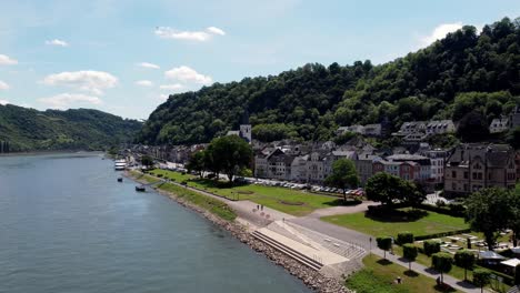 Aerial-flying-drone-shot,-tracking-in,-of-the-Rhine-River-Valley-and-Old-Architecture---including-medieval-castles,-old-buildings,-and-natural-forested-alpine-hills