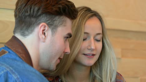 close-up of young couple using mobile phone in cafe 4k