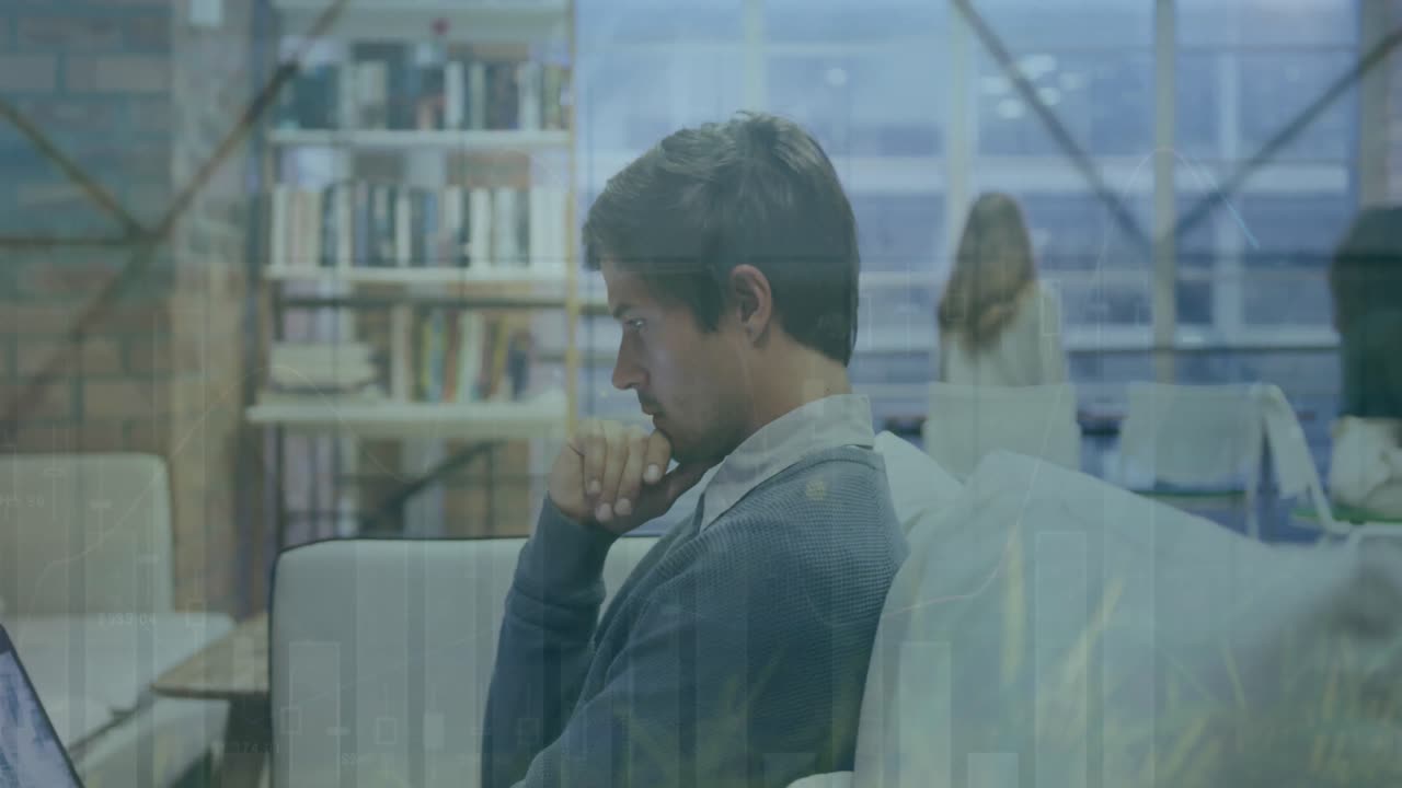 animación de múltiples gráficos y hojas sobre un hombre de negocios caucásico enfocado trabajando en una computadora portátil.