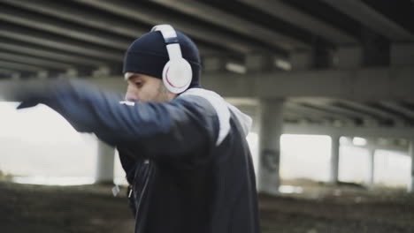 man boxing workout under a bridge