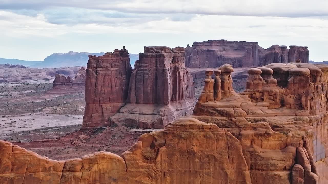 Klippeformationer i Moab Valley, Utah ved solnedgang med en skyet himmel