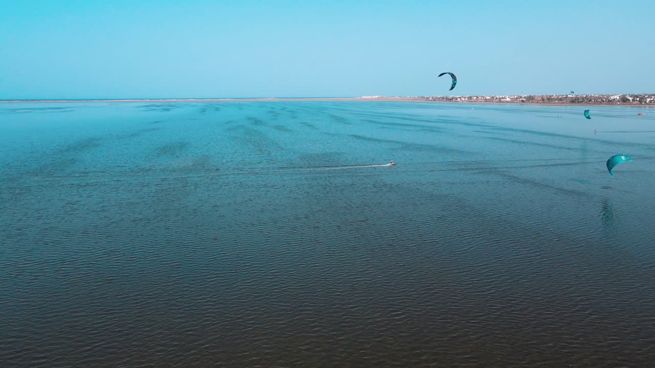 una vista aérea de un cuerpo de agua con personas de windsurf y parasailing, kite surf en el océano de la laguna de djerba en túnez