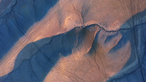 Drohnenaufnahme-Von-Oben-Nach-Unten-Von-Badlands-In-Factory-Butte,-Utah,-Mit-Reifenspuren-Von-Offroad-Fahrzeugen