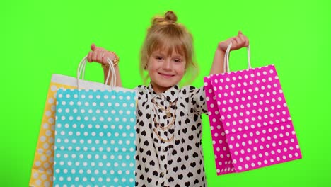 Niña-Mostrando-Bolsas-De-Compras,-Descuentos-Publicitarios,-Precios-Bajos,-Compras-En-Los-Días-Festivos-Del-Viernes-Negro