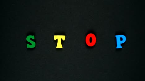 word stop formed of wooden multicolored letters. colorful words loop. stop motion animation