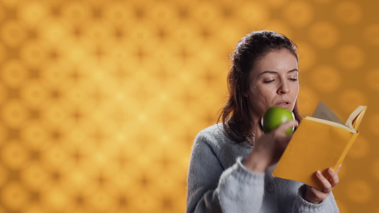 mujer leyendo un libro y disfrutando de una manzana fresca, viviendo saludable, fondo de estudio