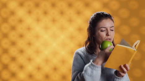 Mujer-Leyendo-Un-Libro-Y-Disfrutando-De-Manzana-Fresca,-Viviendo-Sanamente,-Fondo-De-Estudio