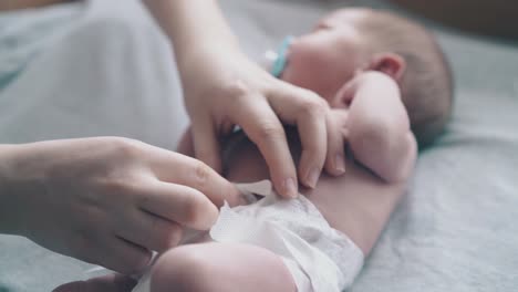 mother hands treat newborn son umbilical cord care