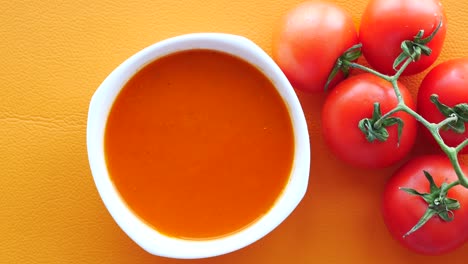 Tomato-soup-on-wooden-table,-top-view