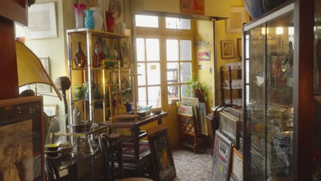 medium view of antique store entrance doors with vases and figurines behind glass showcases