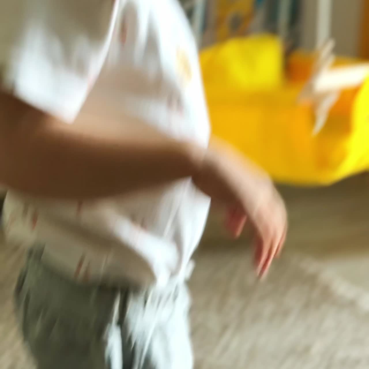 Adorable baby boy puts on soft slippers which are too big for him. Toddler walks by the room wearing mom's home footwear. Vertical screen