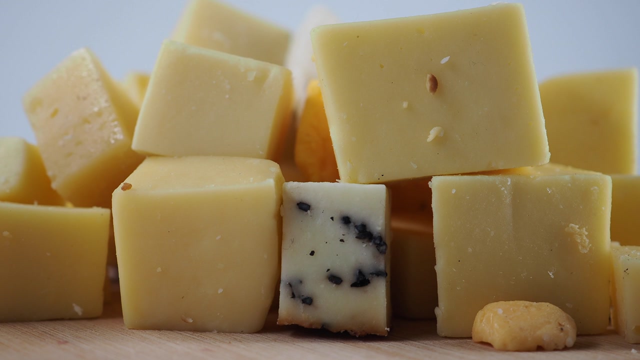 Close-up of Various Cheese Cubes on a Wooden Board