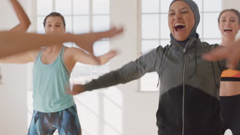 Feliz-Mujer-Musulmana-Bailando-Grupo-De-Personas-Sanas-Disfrutando-Del-Ejercicio-Practicando-Movimientos-De-Baile-Coreográficos-Divirtiéndose-En-El-Gimnasio