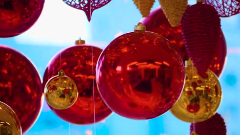 christmas and new year decoration. christmas big red balls on  background of luminous lanterns and gold garlands. holiday background. blinking garland. red baubles with lights twinkling close up.