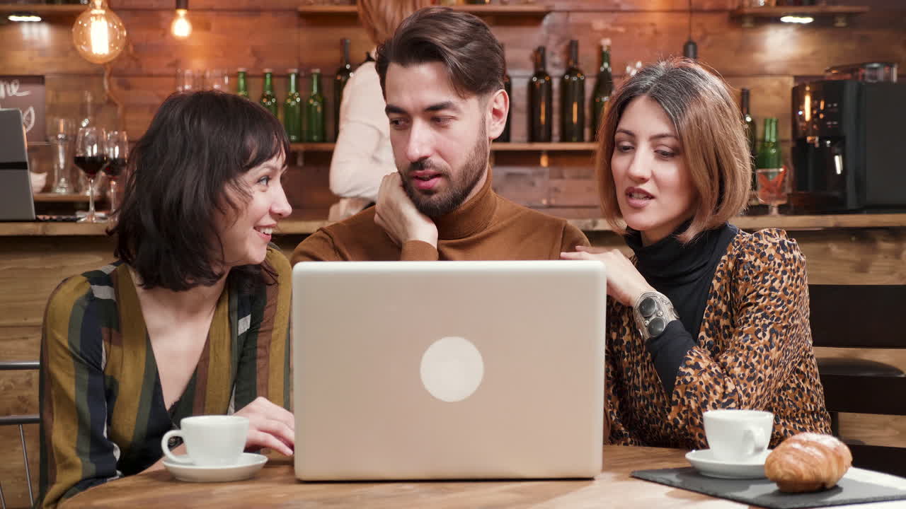 personas trabajando en una computadora portátil en un café