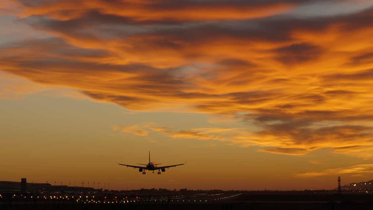 silueta de avión comercial aterrizando en el aeropuerto durante la espectacular puesta de sol