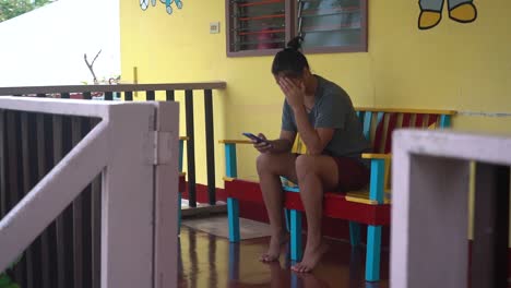 Niña-Huérfana-Filipina-Solitaria-Y-Triste-Mirando-La-Foto-De-Su-Madre-En-Su-Teléfono-En-El-Hogar-Del-Orfanato-En-Filipinas---Plano-Medio