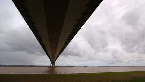 panning shot right to left, looking up under the humber bridge and stopping in the middle on the south shore