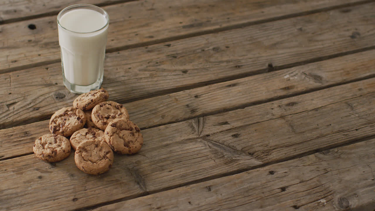 Video of biscuits with chocolate and milk on wooden background