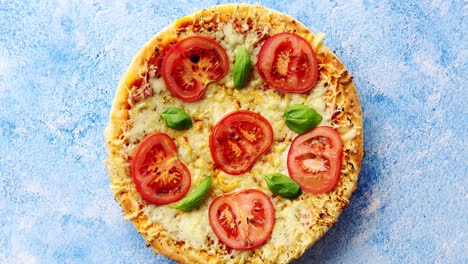 Pizza-with-cheese-and-tomatoes-on-blue-stone-table