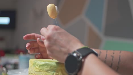 cerca de las manos de una mujer caucásica, decorando un pastel con un oso y un globo hecho de pasta de azúcar fondant en casa 4k pan shot, bokeh de enfoque selectivo