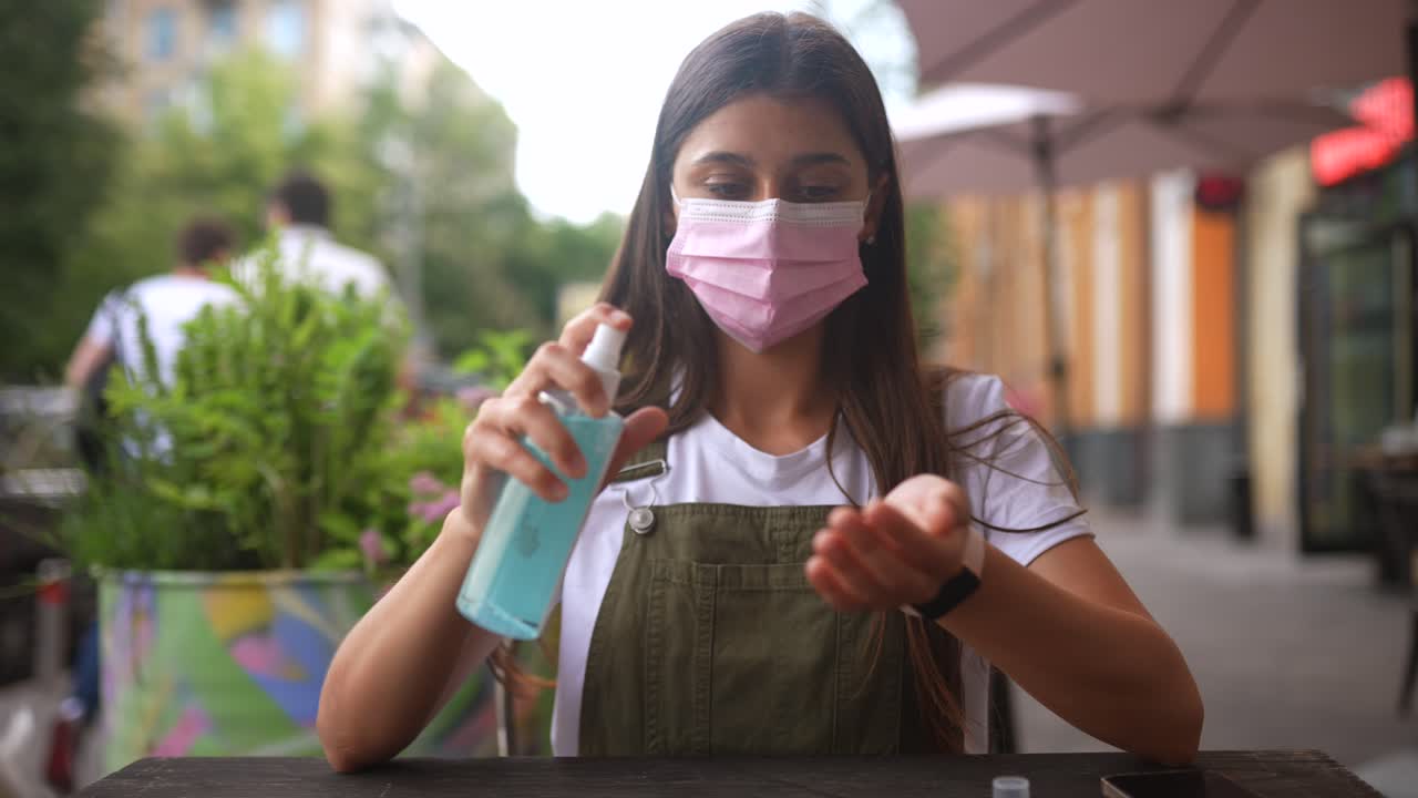 mujer usando desinfectante de manos al aire libre