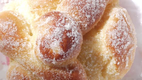 tilt up closeup of sugary sweet bread, pan de muerto. bone-shaped decoration on bun top. typical mexican sweet on all saints day, dia de los muertos.