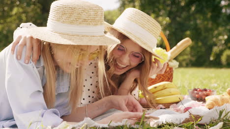 two friends having fun on a picnic in the park