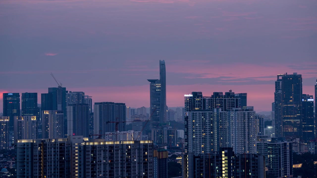 Kuala Lumpur, Malásia, lapso de tempo durante o pôr do sol, Menara Telekom ao fundo, prédio de apartamentos se iluminando.