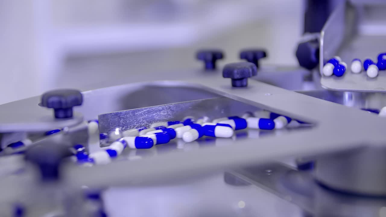 Close up shot from blue and white pills in a machine. Covid-19 pandemic cure. Coronavirus