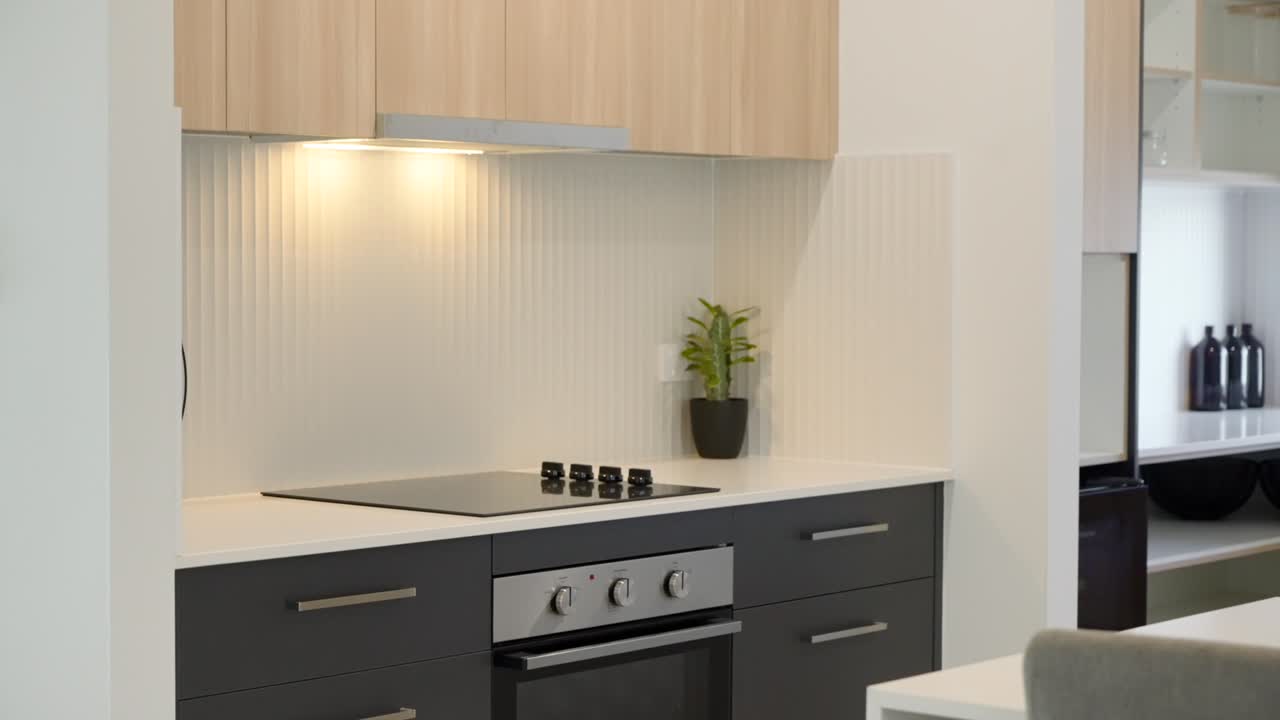 interior de cocina moderno con acabados elegantes, isla grande y diseño minimalista en una casa de exhibición en escena