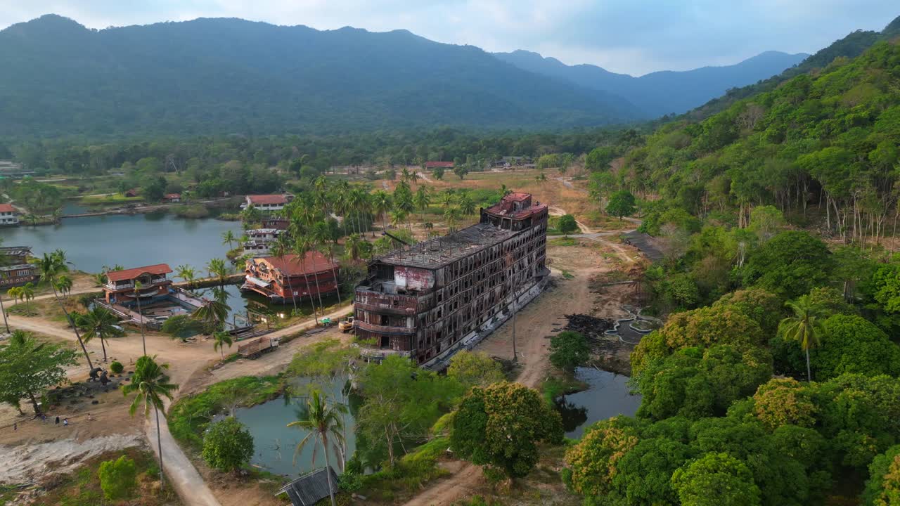 Abandoned resort showing decaying buildings, surrounded by palm trees and a lake, in Koh Chang, Thailand. Stunning aerial view flight panorama overview drone