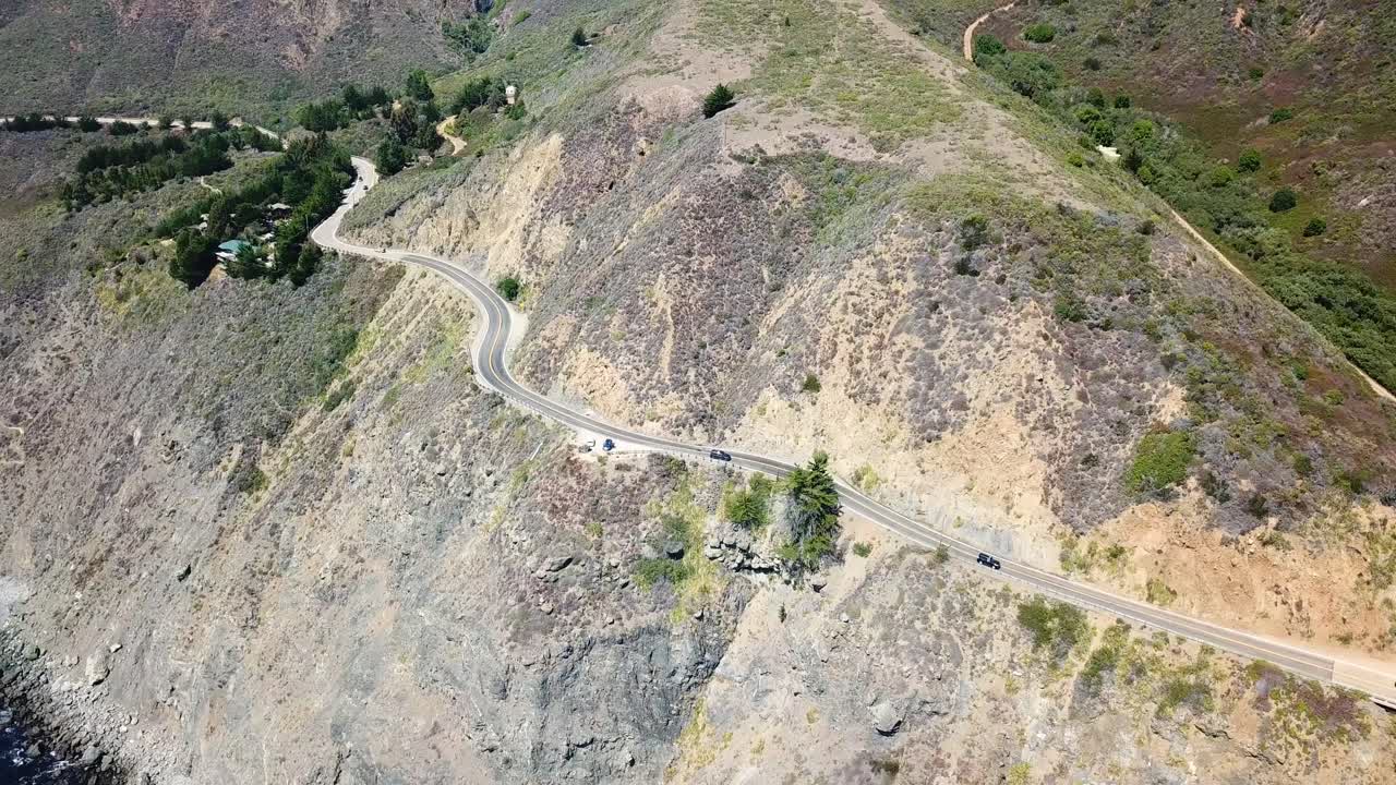 캘리포니아주 1번 도로의 산 가장자리에 있는 경치 좋은 도로를 달리는 자동차