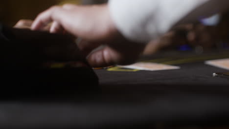 croupier dealing cards at the poker table.