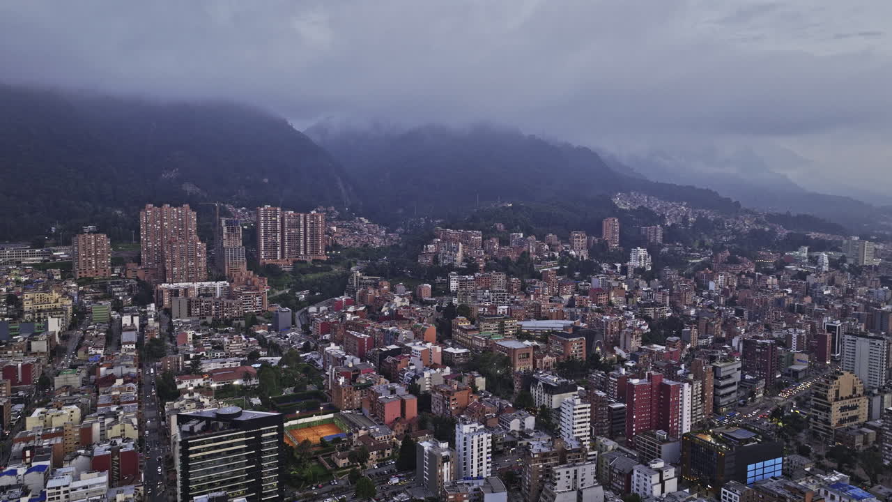 Bogota Colombia Aerial v15 panoramic flyover Chapinero capturing hillside La Salle neighborhood, cityscape and mountainous terrain with misty clouds in the sky - Shot with Mavic 3 Cine - November 2022