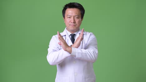 성숙한 일본인 남성, 초록색 배경의 의사
