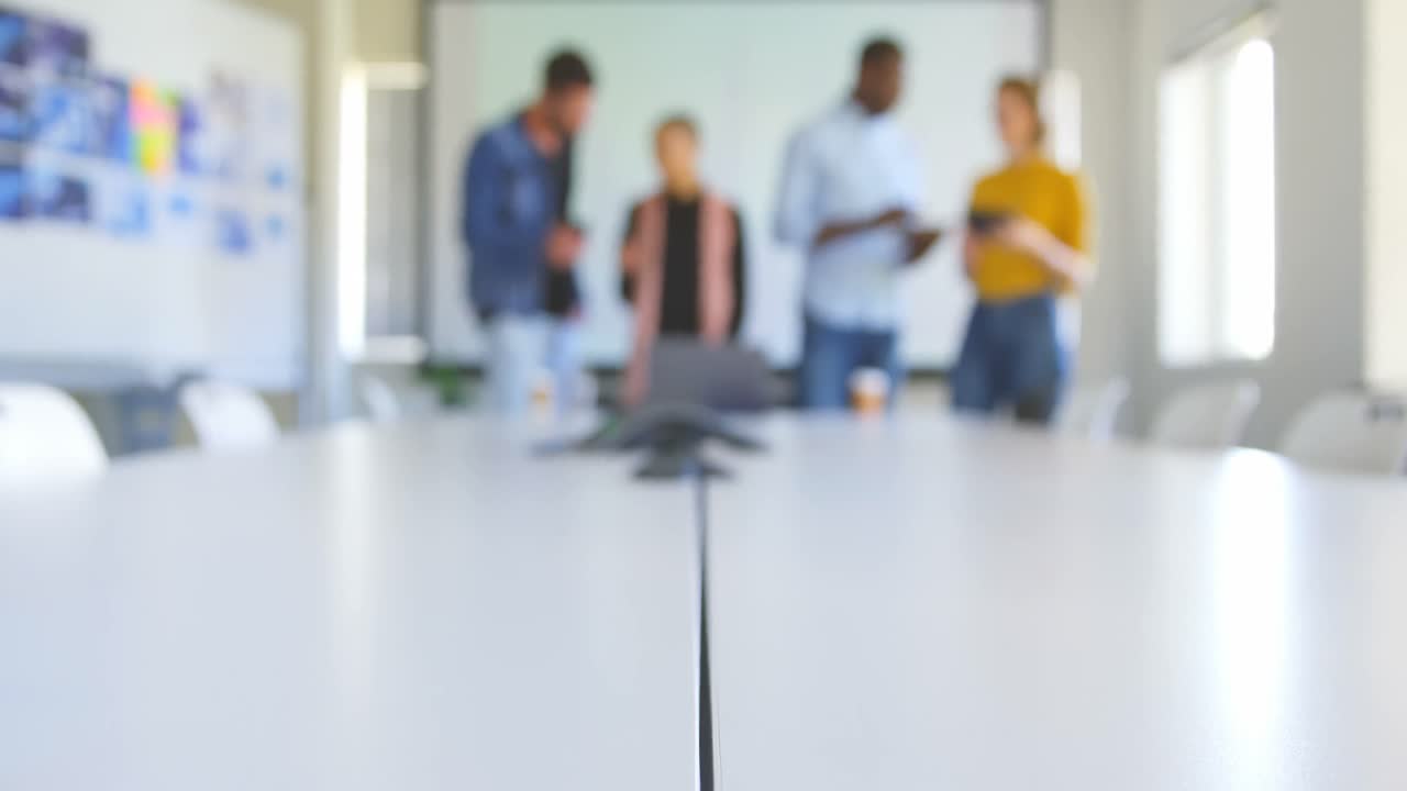 Mangfoldigt forretningsteam arbejder med multimedieenheder på moderne kontor 4k