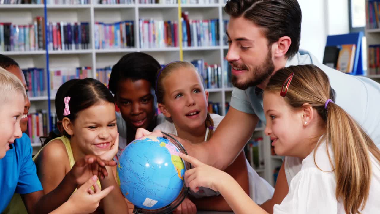 el maestro discutiendo el globo con los niños en la biblioteca