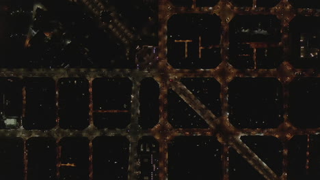 Overhead-view-of-street-network-in-night-city.-Illuminated-streets-in-urban-borough.-Barcelona,-Spain