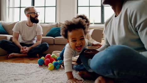 happy family playing with toddler in living room