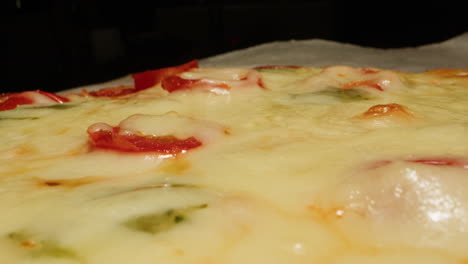 close-up of a baking pizza with melted cheese and toppings