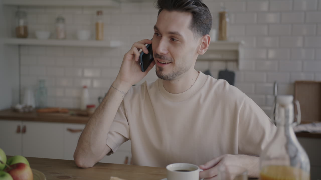 Man talking on phone while eating breakfast