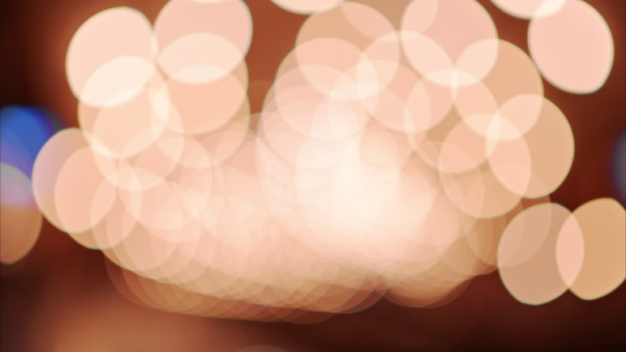 Blurry view of people and trains moving through the train station with bright lights