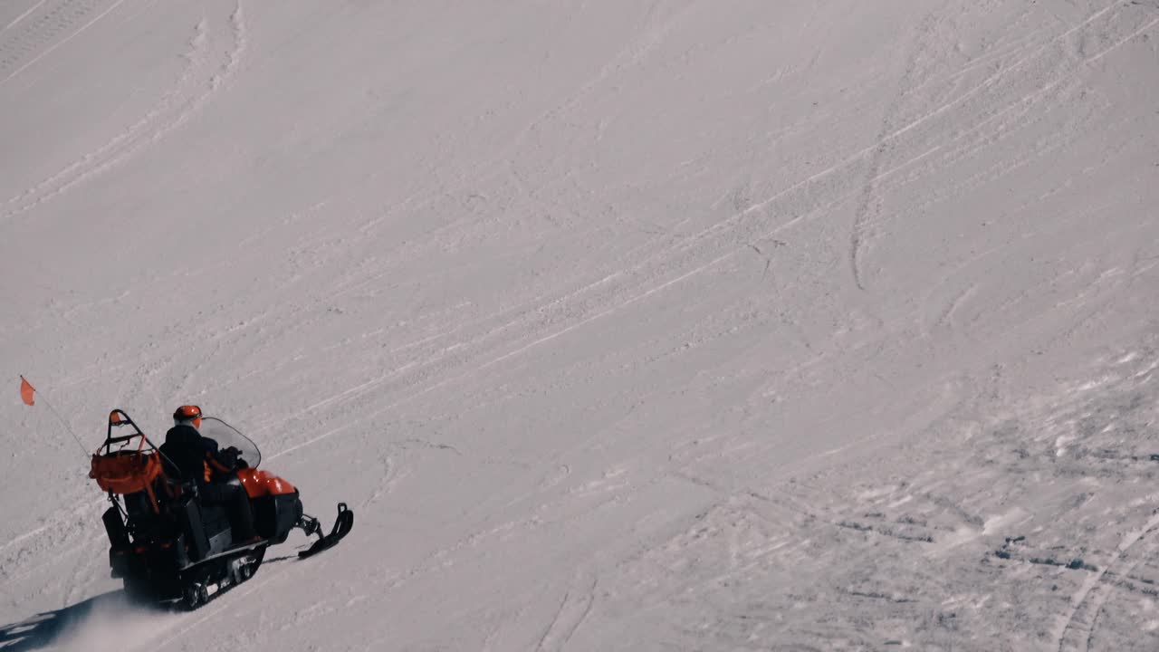 persona yendo cuesta arriba en un scooter de nieve