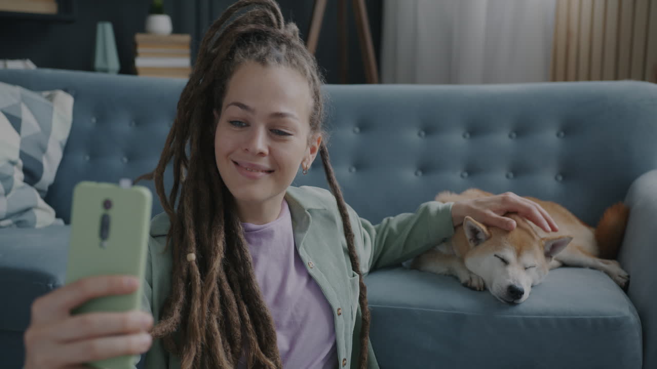 Donna che scatta un selfie con il suo cane sul divano